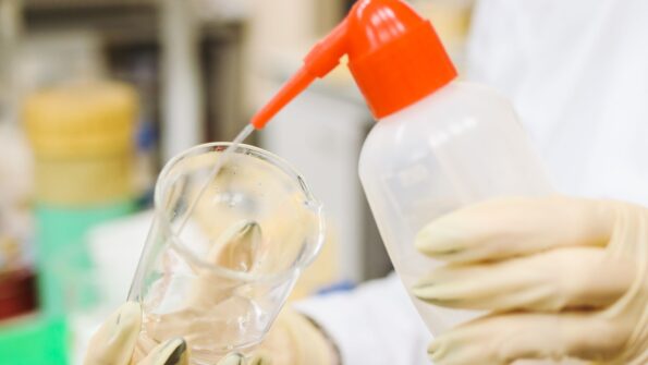 科学家用塑料瓶往玻璃烧杯里倒液体